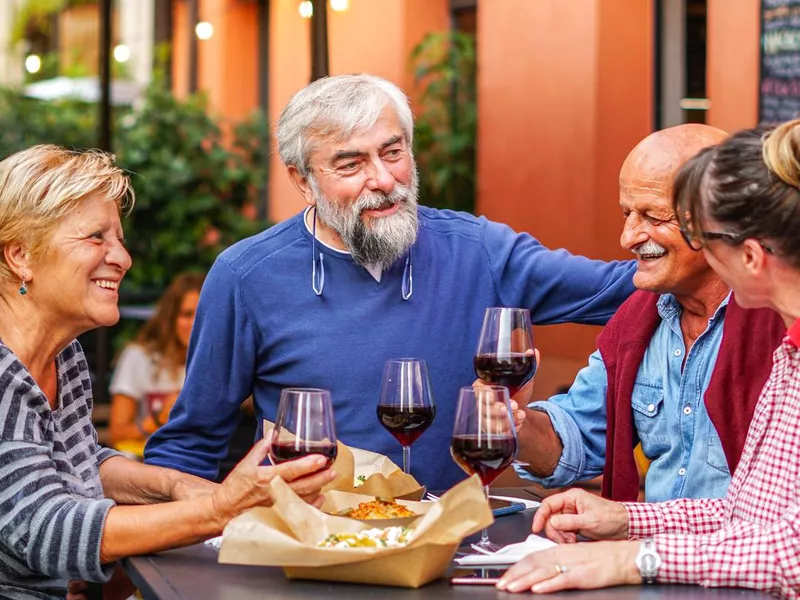 Happy travelers drinking wine during dinner